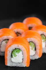 Portion of fresh philadelphia sushi roll on black background