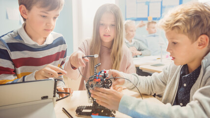 Elementary School Robotics Classroom: Diverse Group of Brilliant Children Building and Programming Robot, Talking and Working as a Team. Kids Learning Software Design and Creative Robot Engineering