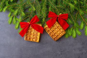 Christmas decoration on a dark stone background with waffles, red bows