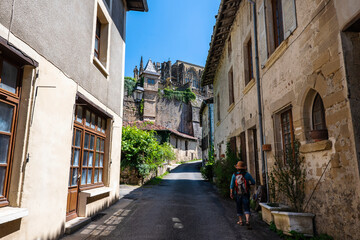 Fototapeta na wymiar Medieval street of the most beautiful french village of Saint-Antoine-l'Abbaye with a tourist walking up the old center. France 2020.