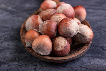 Hazelnuts in a spoon on a dark background