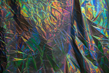 Abstract shiny material. Crumpled iridescent colored fabric.