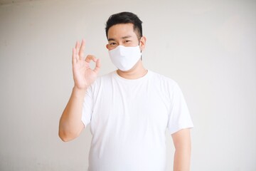 A man in casual shirt wearing medical mask.