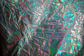 Abstract shiny material. Crumpled iridescent colored fabric.