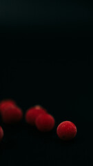 red frozen cranberries on black background