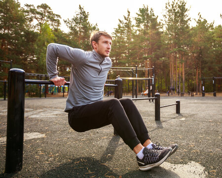Young sports athlete fitness. Exercise Parallel Bars Outdor. Sport, workout, gym, exercising, training and lifestyle concept.