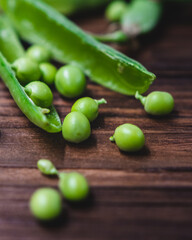 fresh green peas in a brown bowl on a wooden table