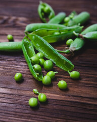 fresh green peas in a brown bowl on a wooden table
