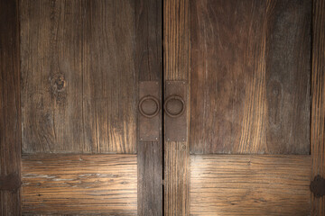 Beautiful brown wooden oak doors of a cabinet with rusty metal modern handles modern background texture