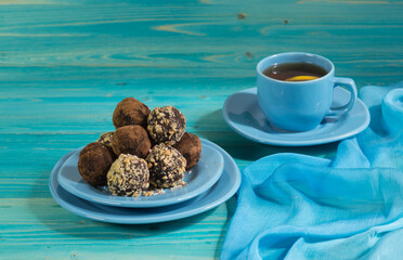 A portion of homemade energy balls and a Cup of tea on a blue wooden table. Delicious, healthy dessert. Lifestyle. Diet