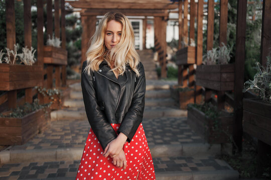 Blond young woman on red dress wild hair looking to the camera