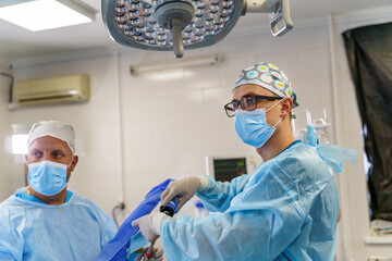 Portrait of the professional medics in surgical masks during operation. Modern hospital operating...