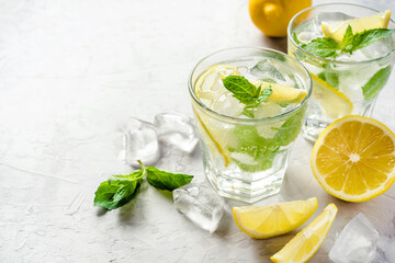 Cold refreshing lemonade or mojito with ice and mint leaves.