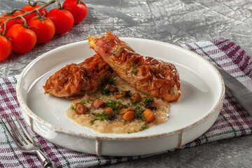 Chicken drumstick ballotin with onion sauce and mushrooms. Stuffed chicken legs