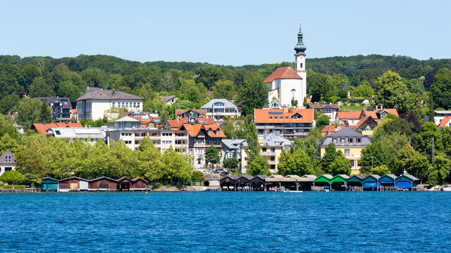 View on the town of Starnberg with lake Starnberger See in the foreground. With colorful boat houses and church St. Josef.