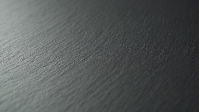 Slate textured dark surface close-up. Slow rotation. Gray shabby stone background