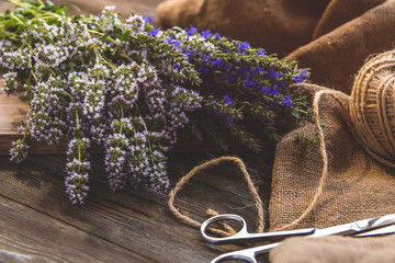 Bunches of medicinal herbs with purple and blue flowers copy space. Thyme and hyssop flowers on a wooden table.