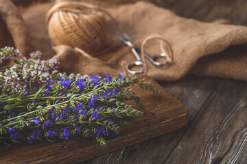 Obraz na płótnie Canvas Bunches of medicinal herbs with purple and blue flowers copy space. Thyme and hyssop flowers on a wooden table.