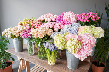 Many different colors on the stand or wooden table in the flower shop. Showcase. Background of mix of flowers. Beautiful flowers for catalog or online store. Floral shop and delivery concept. Top view