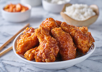 crispy fried korean chicken wings in soy garlic sauce with pickled radish and kimchi sides