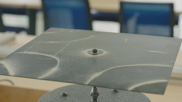 Close up shot of a resonance experiment with sound and sand