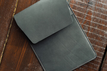 black leather case for tablet. eco leather case on a wooden background