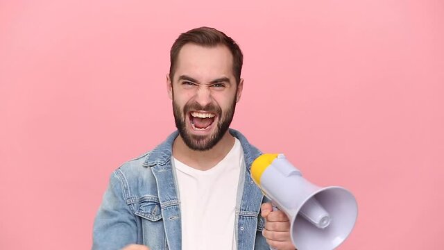 Fun young man guy 20s years old in denim jacket white t-shirt isolated on pastel pink background studio. People lifestyle concept. Looking camera scream in megaphone announces discounts sale Hurry up