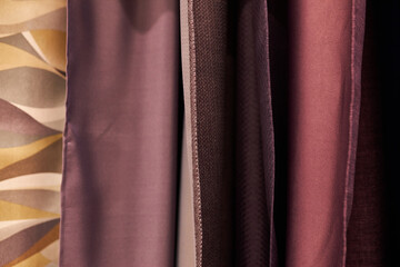 multi-colored curtains in the store. texture of multi-colored fabrics, closeup. samples of...