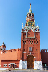 Fototapeta na wymiar View of Spasskaya Tower with large clock of Moscow Kremlin built from red bricks on a summer morning. Clear blue sky in the background. Theme of travel in Russia.