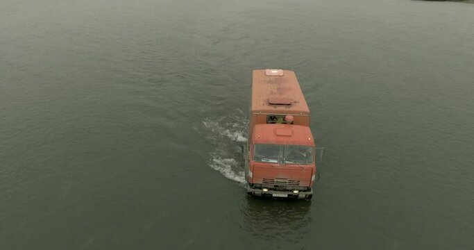 Crossing the river with a six-wheel drive truck. Bear trip to the Kuril lake in Kamchatka in Russia. Kamchatka Peninsula.