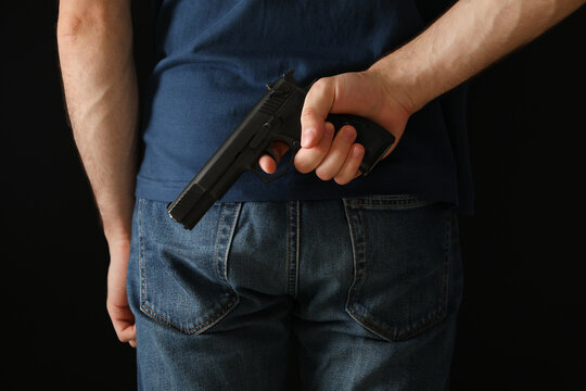 A man hold a gun from behind. Self defense weapon
