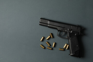 Pistol and traumatic bullets on dark gray background. Self defense weapon