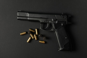 Pistol and traumatic bullets on black background. Self defense weapon