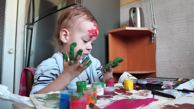 Little boy smeared in paint