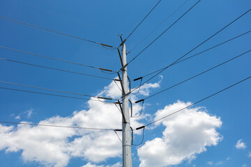 Obraz premium High voltage electric power utility lines with blue sky and fluffy clouds