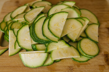 Green zucchini cut into circles on a wooden Board. Zucchini crop.
