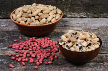Peeled peanuts and shells in a plate. Front view.