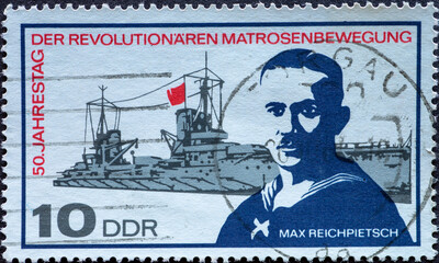 GERMANY, DDR - CIRCA 1967: a postage stamp from Germany, GDR showing a warship with Max Reichpietsch. Text: 50th anniversary of the revolutionary sailor movement