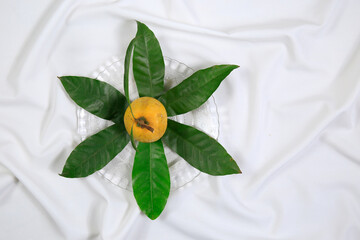 Fresh tasty eggfruit decorated with leaves on a glass bowl
