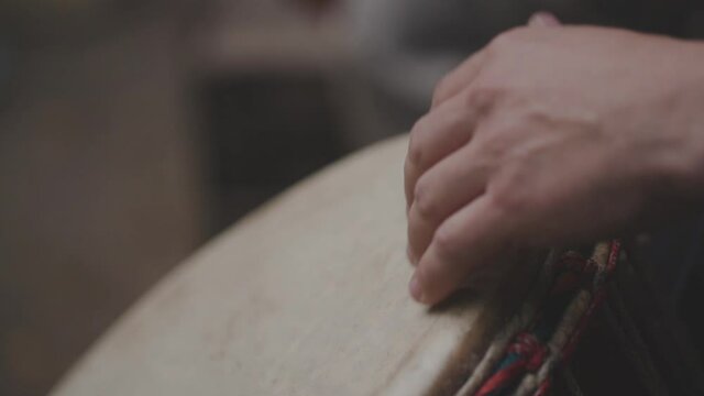 Close up view of hands playing music at djembe drums.