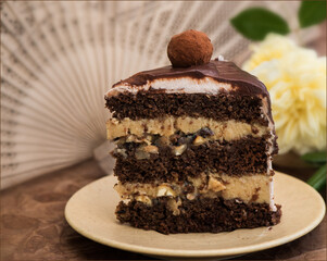A piece of chocolate cake with vanilla curd cream, with hazelnuts in custard and a delicious ball. Sugarless. Decorated with roses.