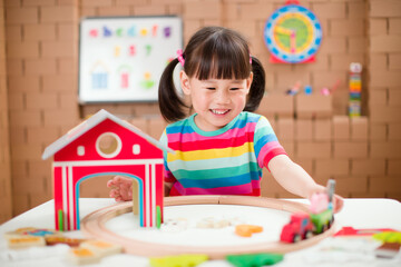 Fototapeta premium toddler girl play train farm toy set for homeschooling