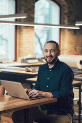 Confident employee of the publishing house at his workplace