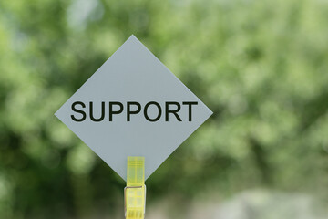 Support text written in color sticker and green background.