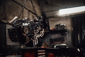 Closeup view of a suspended boxer engine in a dark garage or workshop