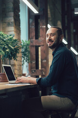 Handsome man under the lamps in stylish office alone