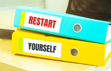 Two office folders with text restart yourself