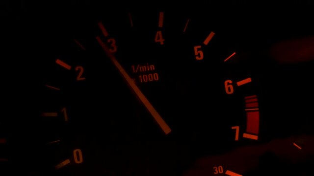 Car dashboard and speedometer with moving red arrow on zero while the automobile is accelerating. Footage. Close up of the car dial, concept of transportation.