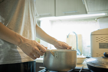domestic cooking. caucasian male person cooking at kitchen. making keto meal. stew chicken fillet with vegetables such as onion and carrot. authentic.