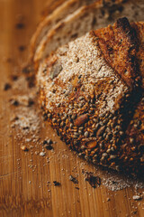 Close up view on freshly baked sourdough bread on wooden cutting board on bright backgrounda